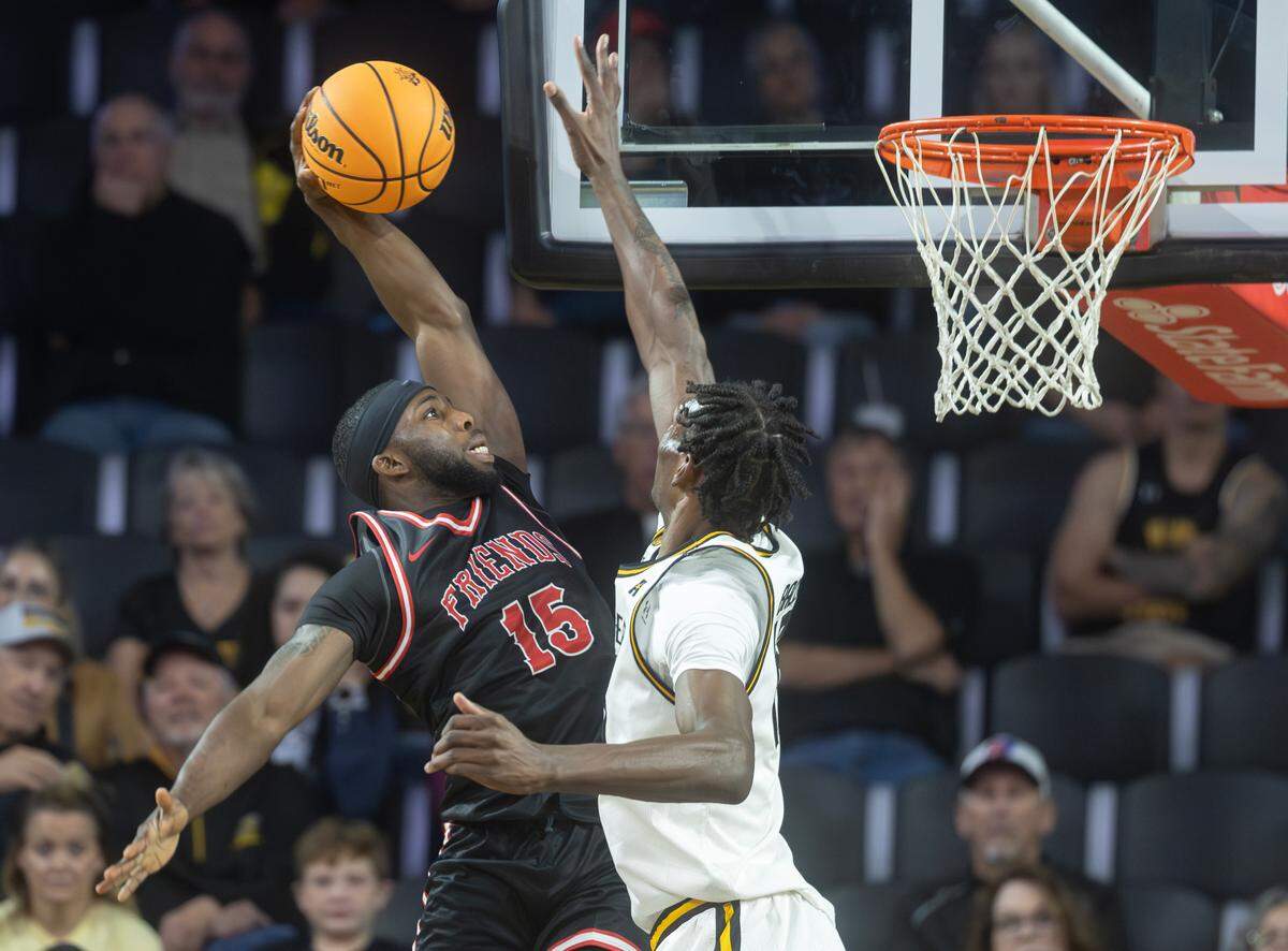 Friends’ Steele Chapman has his shot blocked by Wichita State’s Quincy Ballard during the first half of their game on Sunday at Koch Arena.