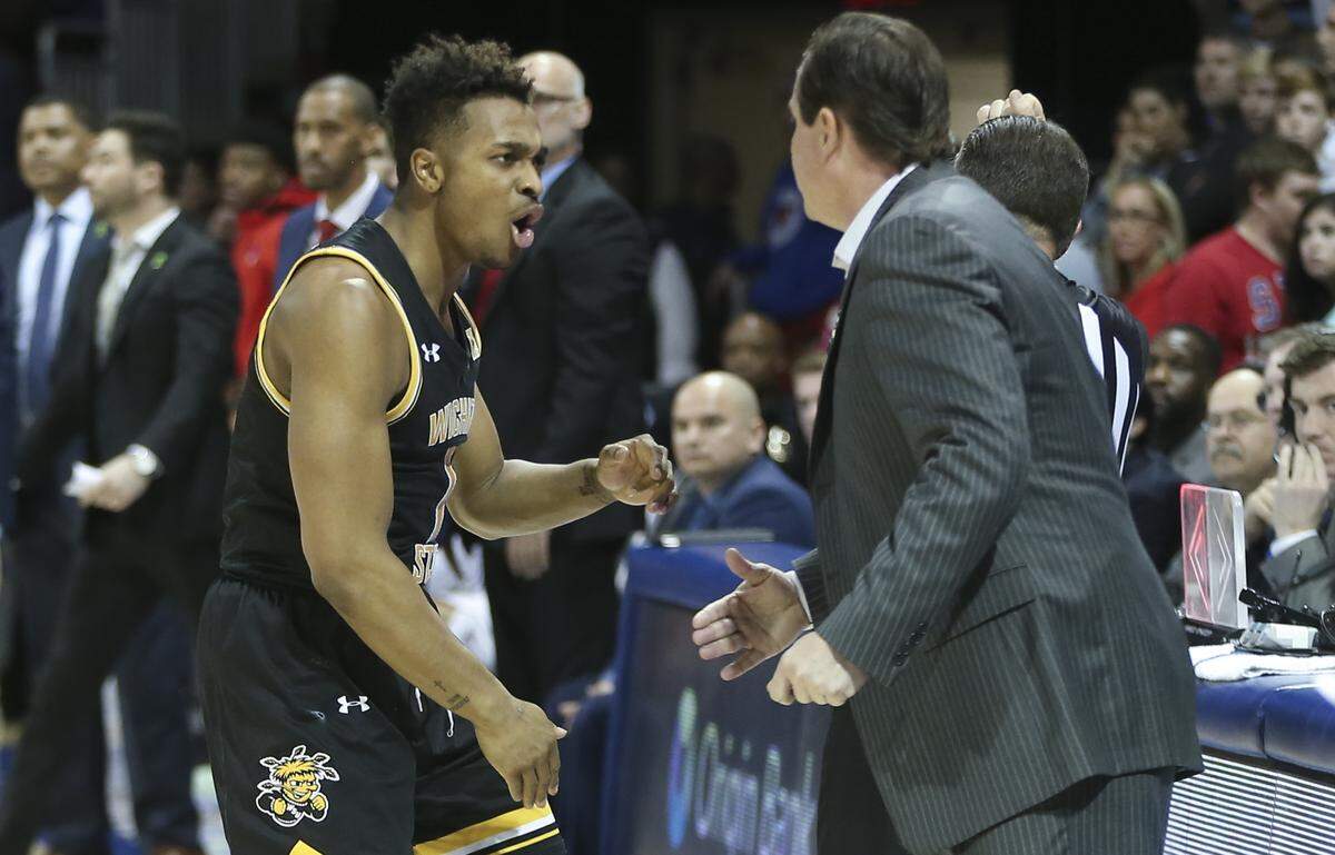 Tyson Etienne celebrates with coach Gregg Marshall while the Shockers chip away at a 24 deficit to SMU in the second half. Wichita State went on to win 66-62.