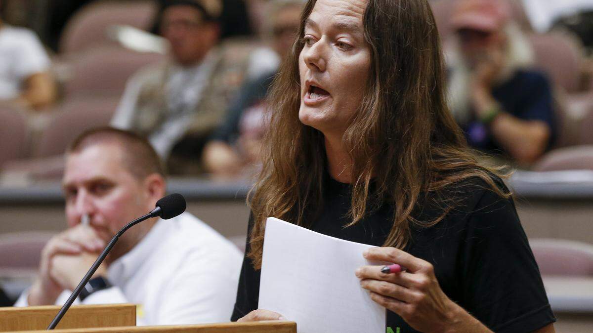 Wichita resident Monica Marks expresses her displeasure about the school playgrounds being fenced and brings a stack of signed petitions of other parents opposed to the fencing during a Board of Education meeting at North High Monday. (July 23, 2018)