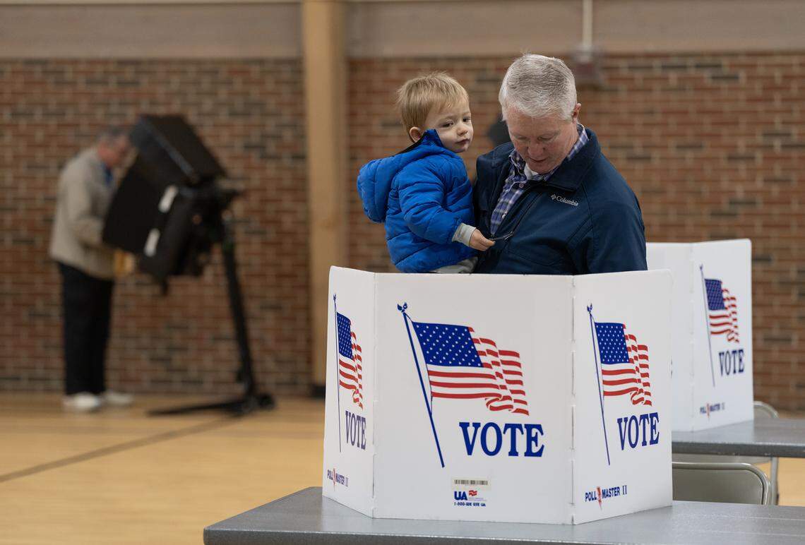 David Shaw holds his son, McKennen, while voting in the special election for the 1%, citywide sales tax referendum at Edgemoor Recreation Center.