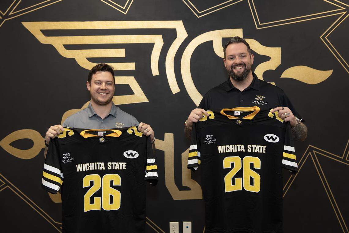 Dynamo Capital co-founders Justin Rocheleau CEO, left, and Matthew Medrano CRO hold up replica Wichita State University football jerseys that Dynamo is giving away at a WSU baseball game.