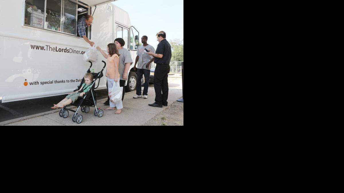 Lilly Cluck gets food from the Lord’s Diner food truck for herself and her sisters (in front and behind her) at Friendship Park. This truck served 16,177 meals in July at this location. (August 4, 2014)


