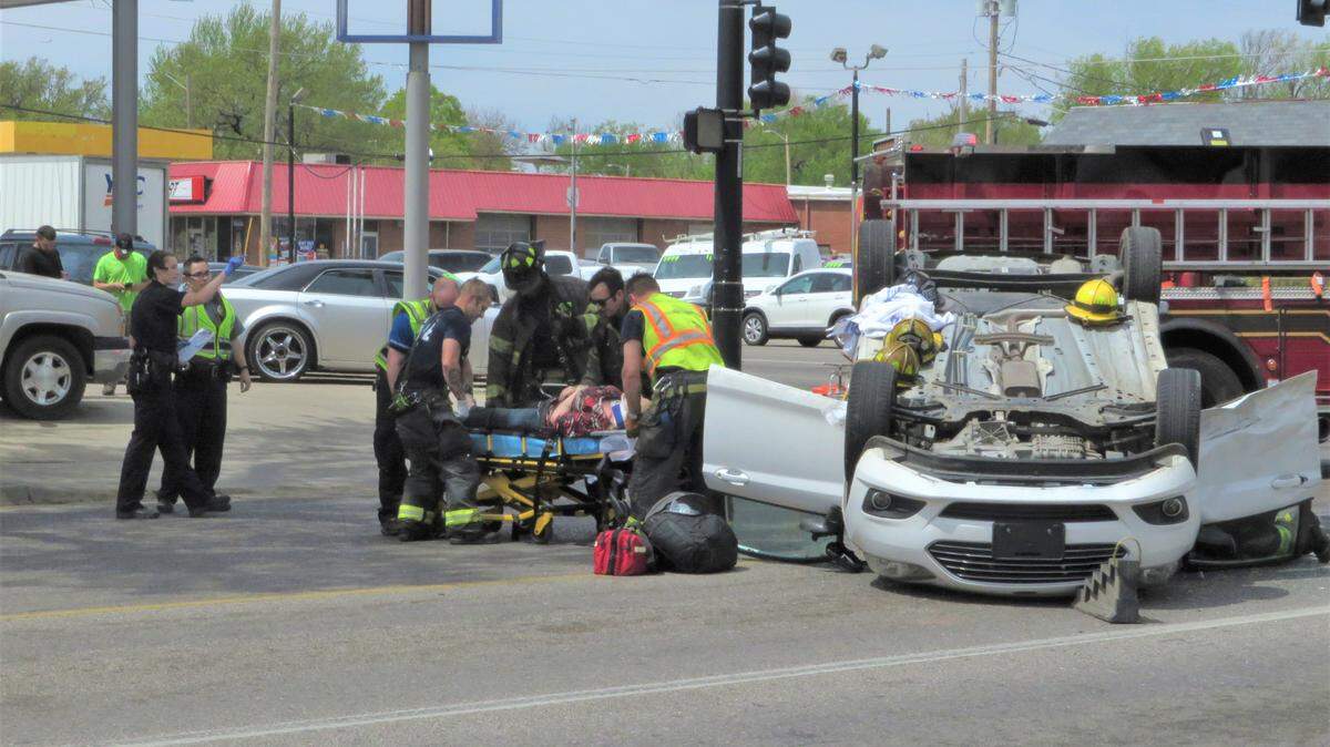 Emergency personnel assist the driver of a car that flipped in a rollover crash at Broadway and 13th Street 
 Tuesday afternoon.