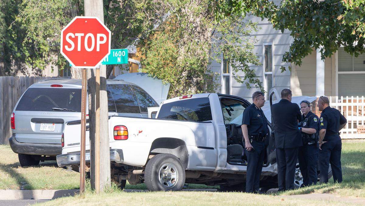 Police chief Joseph Sullivan, left, talks with other members of the department at the scene where a suspect crashed into another motorist at 15th and Meridian while fleeing police.