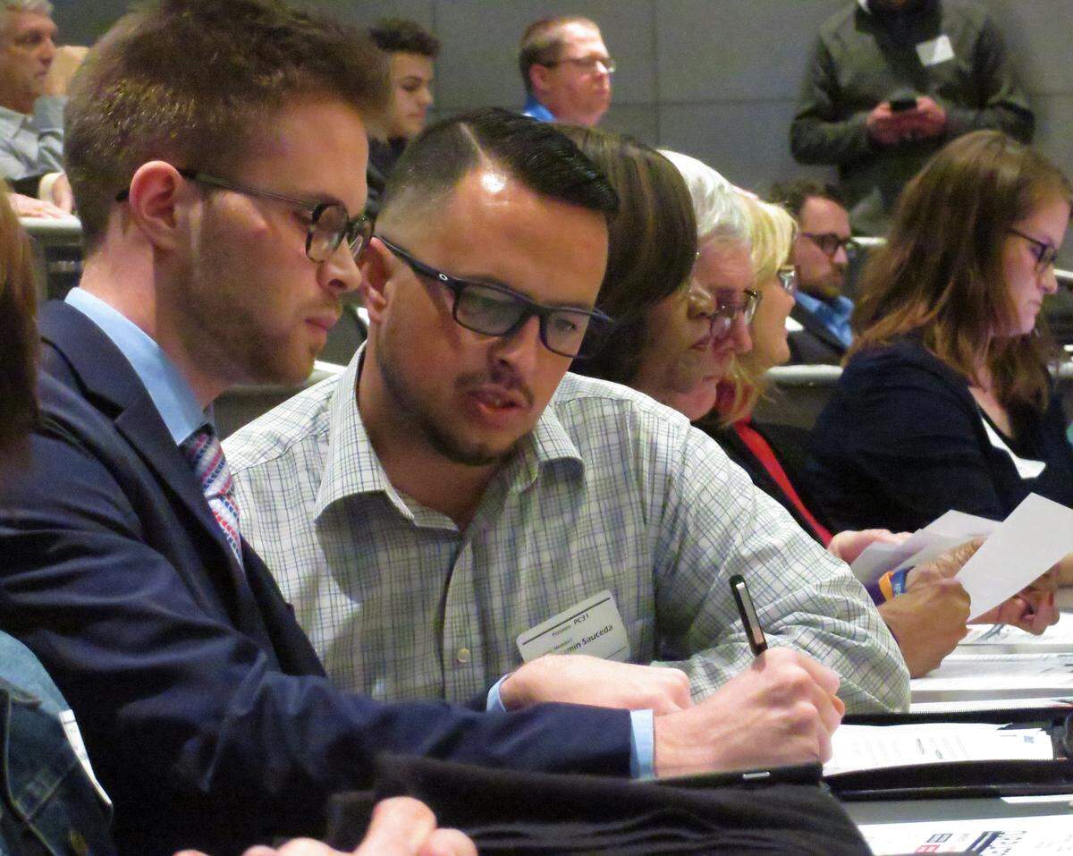 Dalton Glasscock, left, huddles with Ben Sauceda during Thursday’s Sedgwick County Republican Party meeting. Glasscock was elected party chairman and immediately appointed Sauceda as executive director.