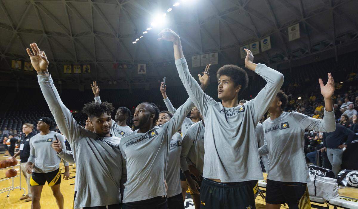 Teammates celebrate with Kenny Pohto after the 6-foot-11 freshman won the Shocker Madness three-point contest on Tuesday.