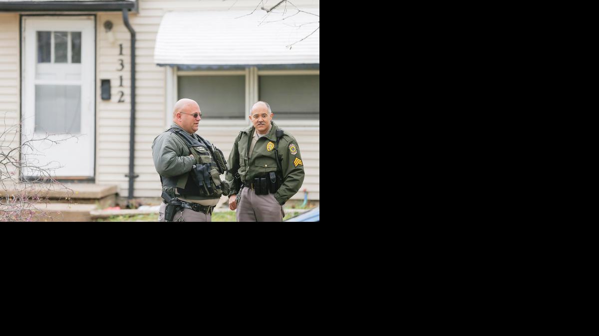 Two Wichita police officers stand in front of a home where a child, thought to be about 1 year old, was shot. (April 29, 2014)

