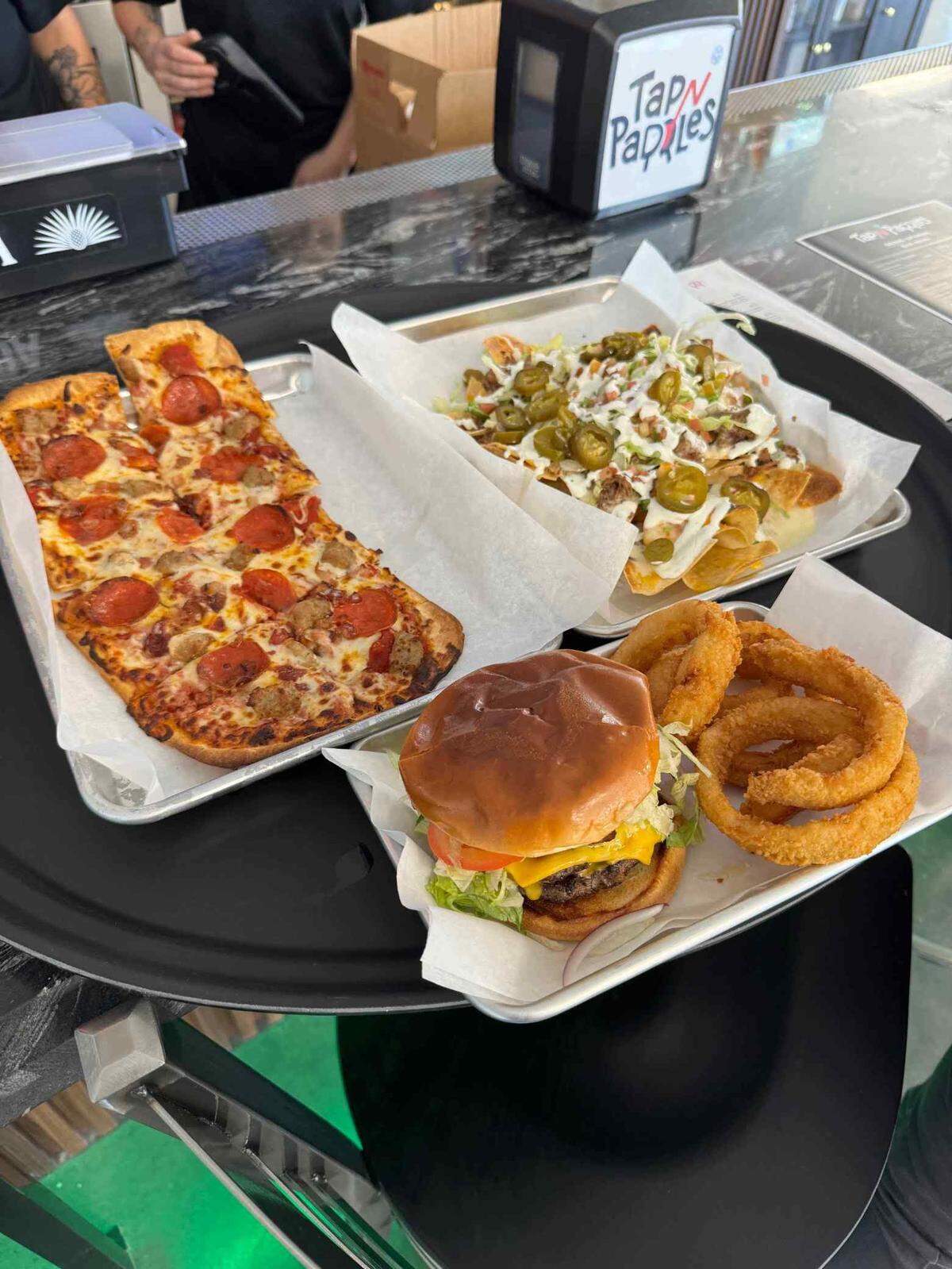 The Tap N Paddles restaurant and bar is open to anyone, even those who don’t want to play pickleball. The menu features flatbreads, sandwiches, burgers and more.