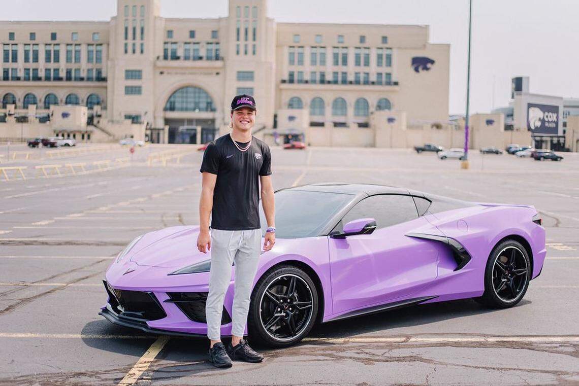 Kansas State quarterback Avery Johnson poses in front of a one-of-a-kind Corvette he received via an NIL deal.