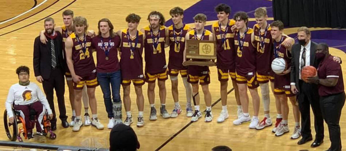 The Hillsboro boys basketball team celebrates with the Class 2A championship trophy after beating Wabaunsee in the finals on Saturday in Manhattan.