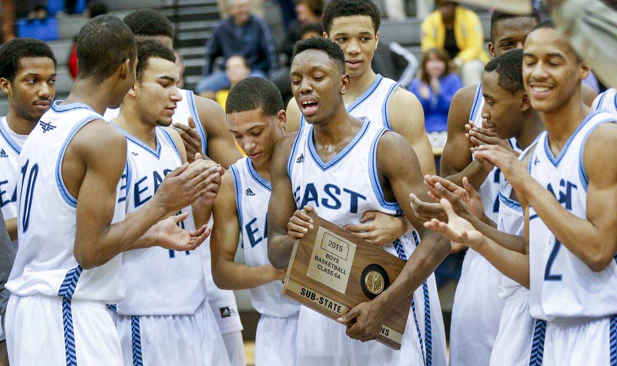 East’s Samajae Jones, center, is overcome with emotion after the Aces received the 6A sub-state champions trophy after defeating Southeast 83-63 at East High Friday. Jones’ mother died of cancer before the season and he’s been dedicating this season to her. His 36 points was against Southeast was a career-high for him. (March 6, 2015)