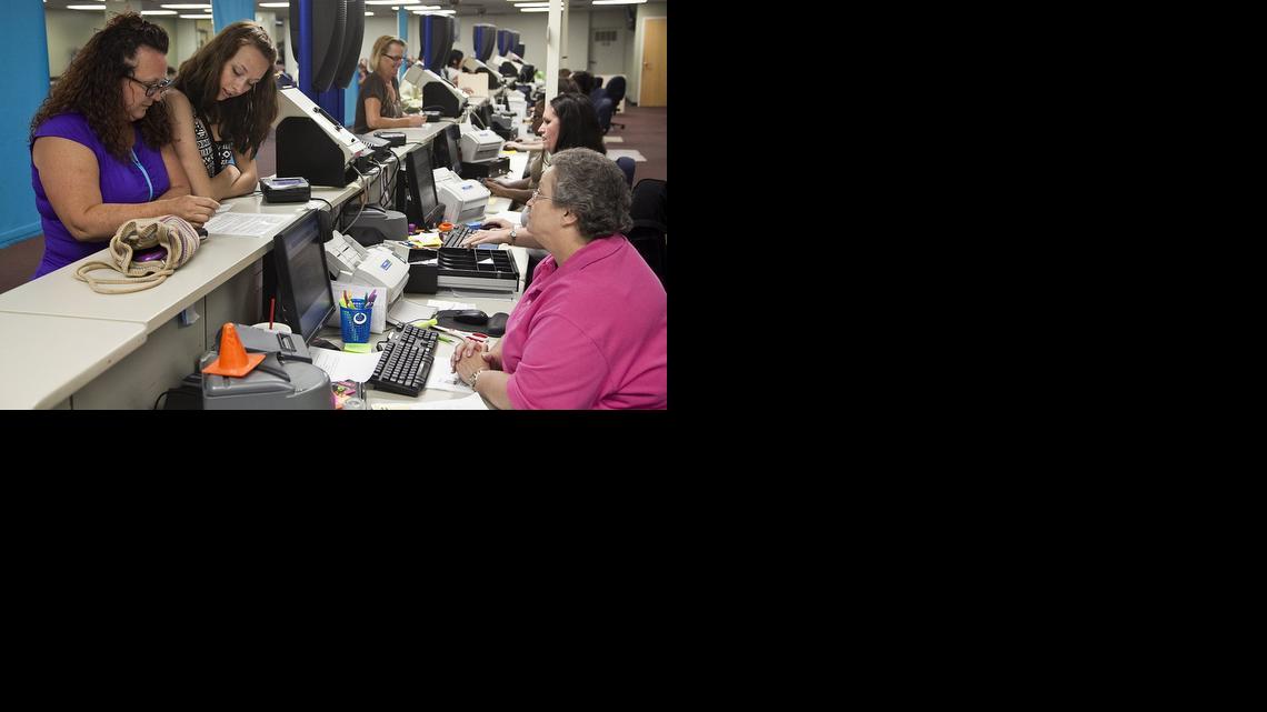 Karigan Kepple, 17, accompanied by her mom, Amber Kepple, left, gets her first driver’s license from clerk Vivian Rollins. Starting Monday, July 8, the driver’s license office in Wichita’s Twin Lakes Shopping Center will be open on Mondays, through Aug. 26, to help alleviate the summer crunch largely brought on by teenagers getting their learner's permit and licenses. (July 8, 2013)