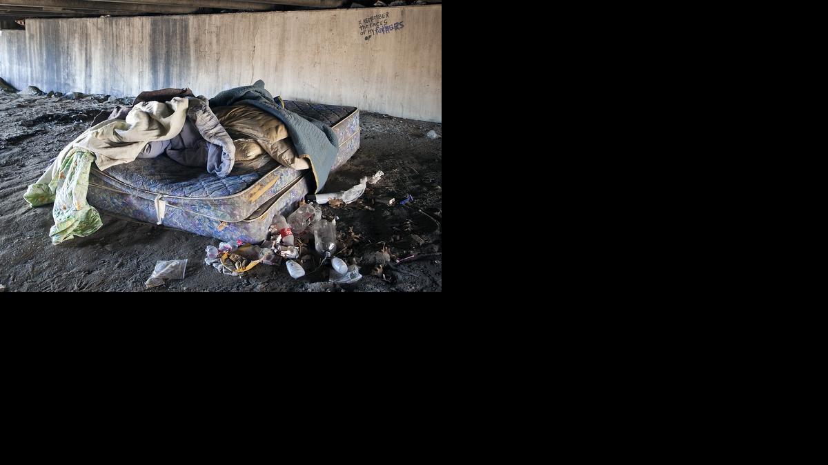 A mattress, blankets, litter and graffiti that reads, “I remember the faces of my fathers,” under the Seneca Street Bridge on Monday where Wichita police found a man’s body near the Mid-America All-Indian Center on Sunday afternoon. (Dec. 30, 2013)

