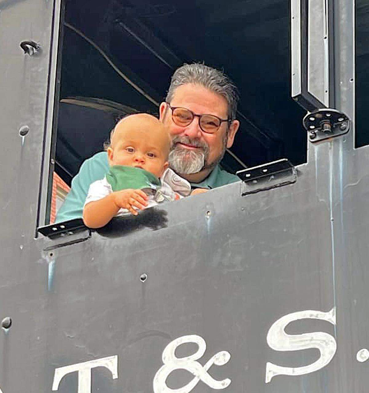 New Great Plains Transportation Museum executive director Lon Smith with is grandson, Ezra, in the cab of a Santa Fe steam locomotive.