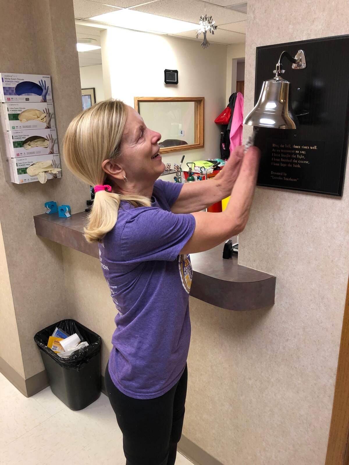 Julie Dombo rings a survivors bell after completing final chemotherapy treatment.
