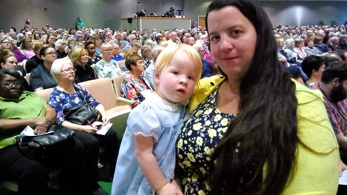 Rachel Porter holds her daughter, Anna, during Thursday’s “Nehemiah Assembly” organized by Justice Together. Porter, a paramedic who is married to a veterinary technician, spoke about her families struggles in finding affordable housing.