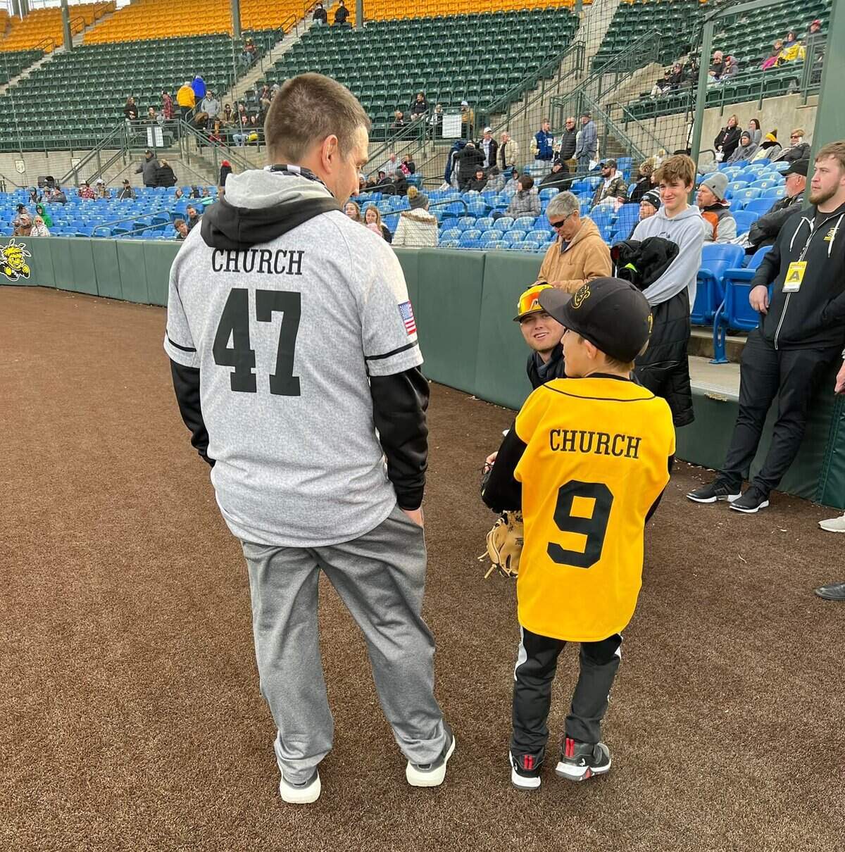 Michael Church (left) chats with his 8-year-old son Kendric after throwing out the first pitch at a Wichita State baseball game.