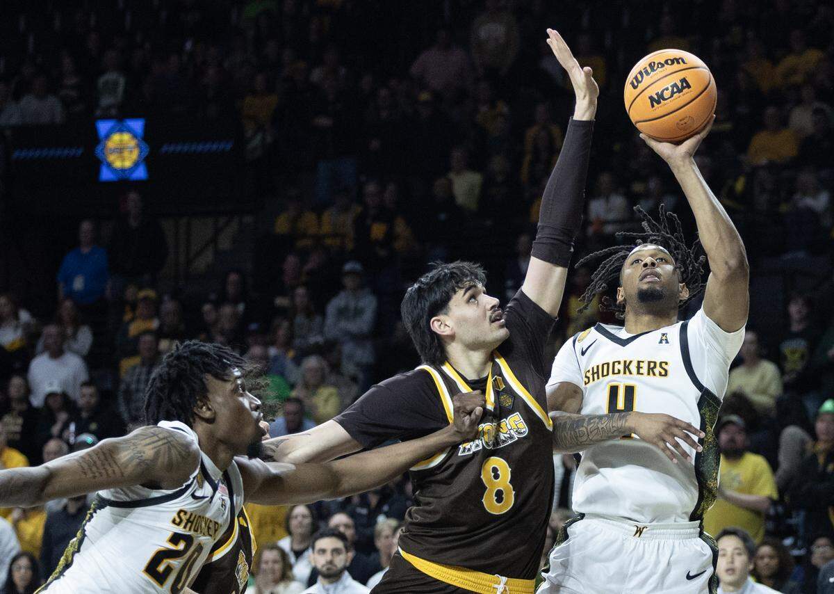 Wichita State’s TJ Williams takes a shot over Wyoming’s Kiani Saxon during the second half of their NIT first round game on Tuesday night at Koch Arena.