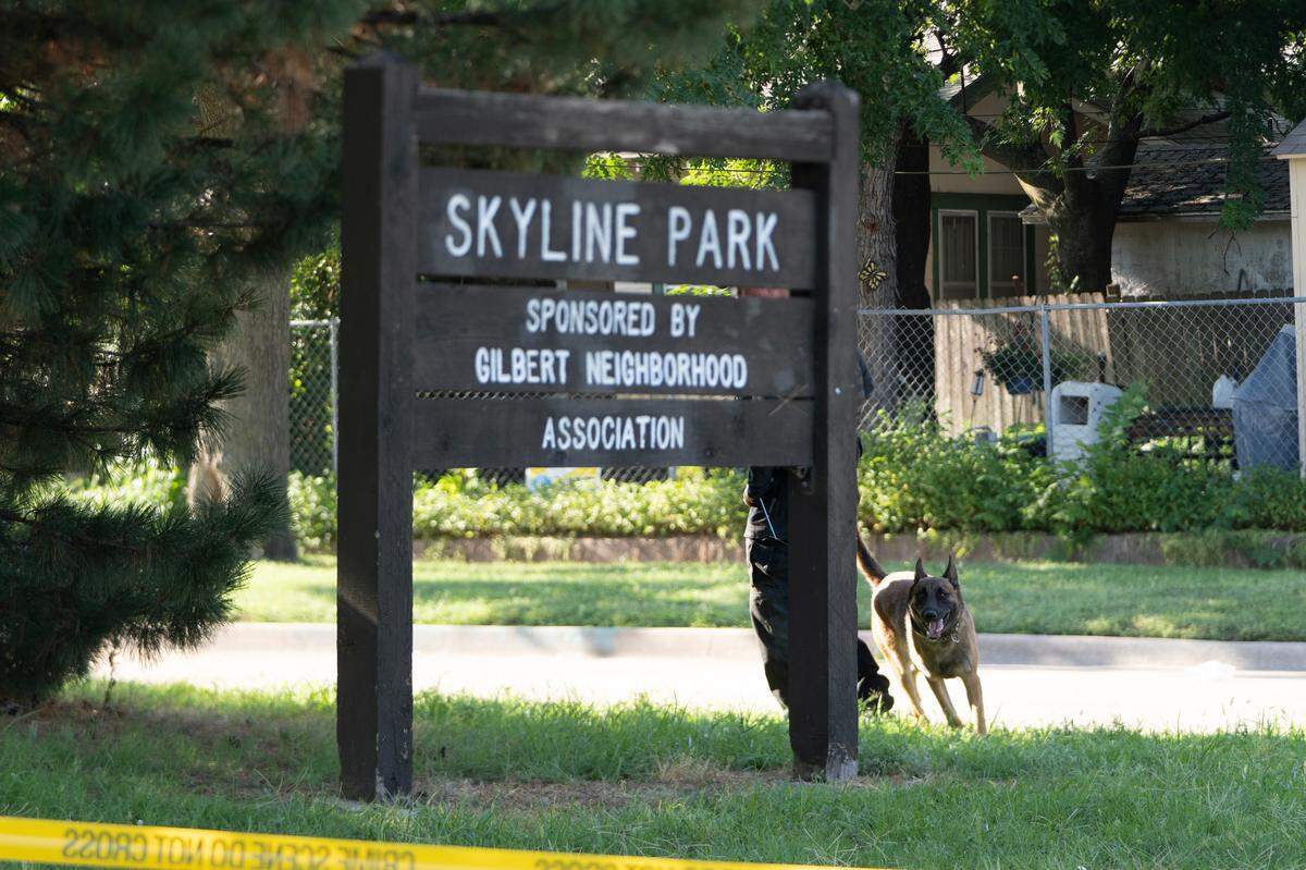 A member of the K9 unit works in Skyline Park on Tuesday morning. Crime scene tape surrounded the park.