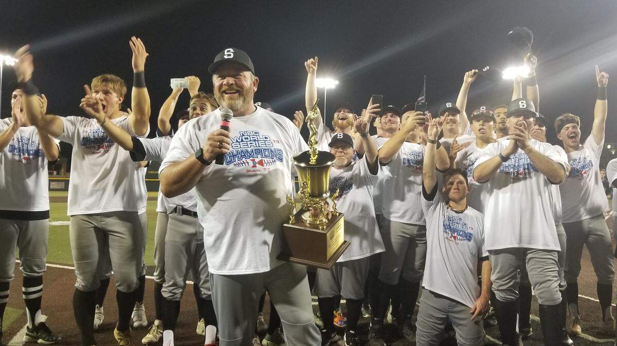 Manager Barry Aden accepts the National Baseball Congress World Series championship following the Seattle Studs’ 5-4 victory over the Cheney Diamond Dawgs at Eck Stadium on Saturday.