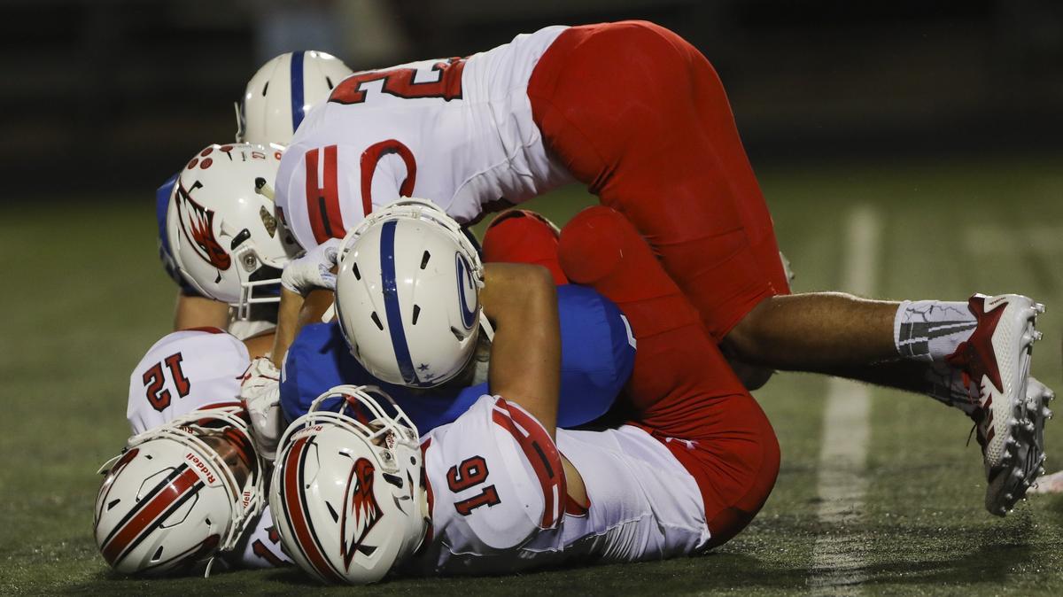 Goddard junior Blake Mitchell is wrapped up by Maize defenders during the game at Goddard High.