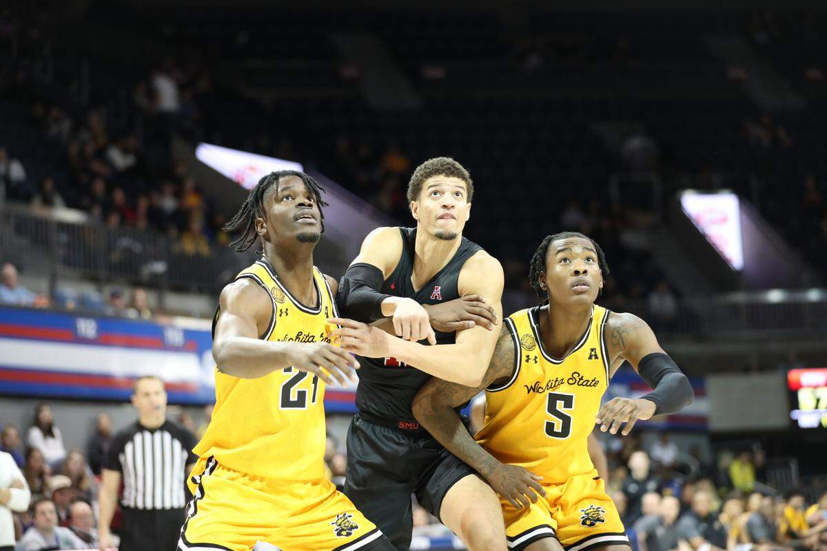Wichita State players Isaac Abidde (24) and Jaron Pierre Jr. (5) box out an SMU player in the Shockers’ 71-69 win at Moody Coliseum on Sunday.