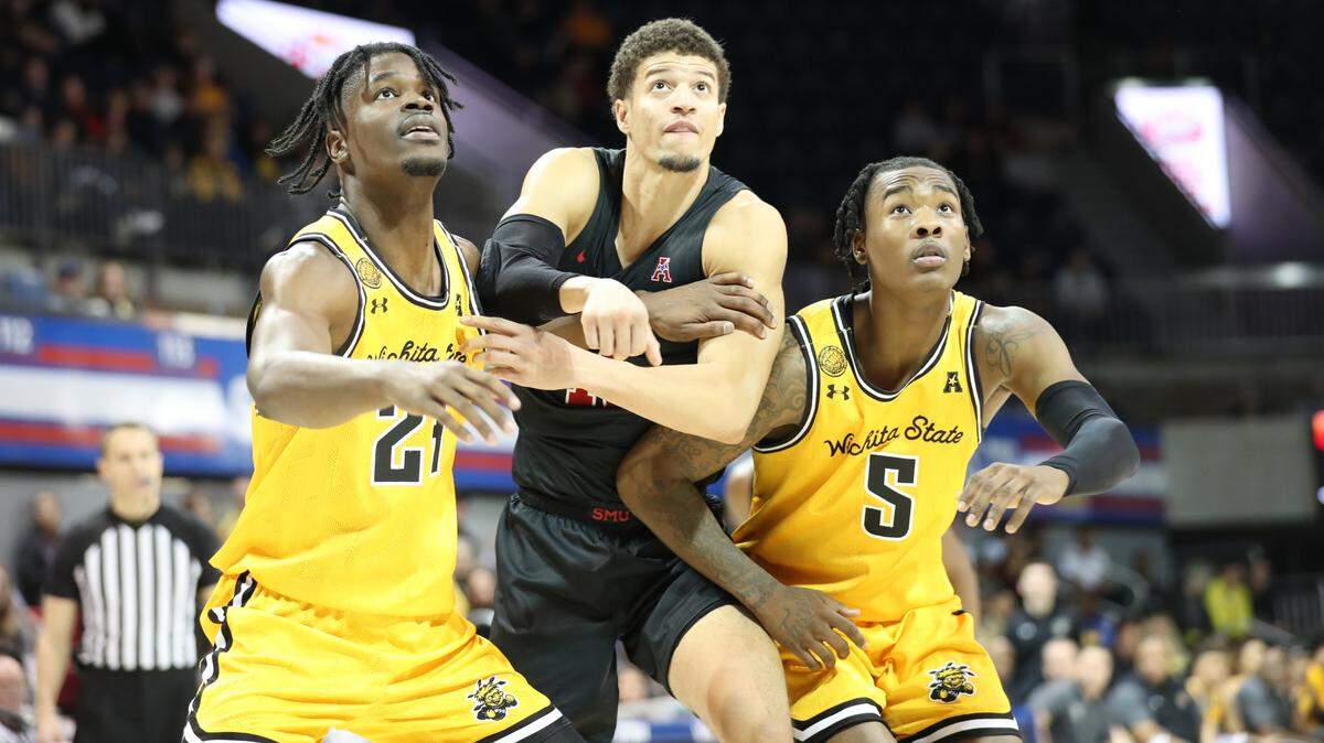 Wichita State players Isaac Abidde (24) and Jaron Pierre Jr. (5) box out an SMU player in the Shockers’ 71-69 win at Moody Coliseum on Sunday.