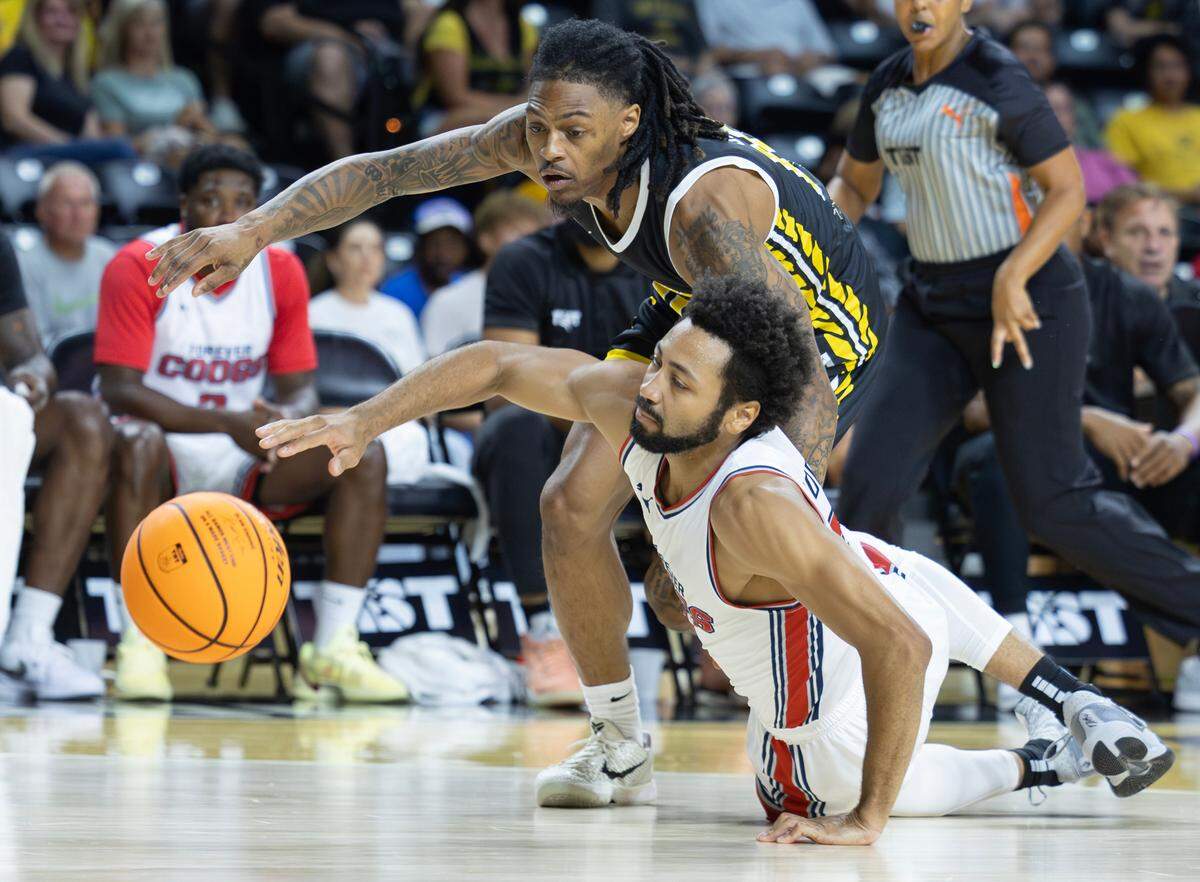 Galen Robinson of the Forever Coogs, bottom, and Nike Sibande of the Aftershocks chase down a loose ball during the first half.