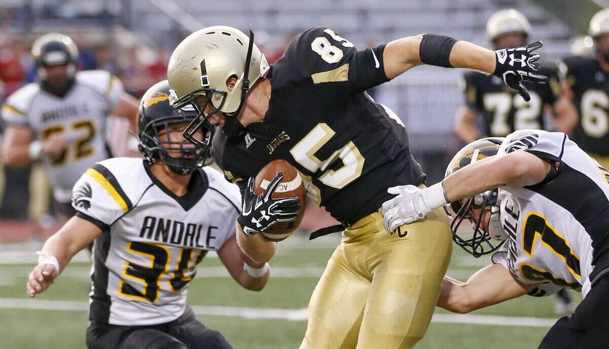 Andover Central’s Peyton Jensen, center, picks up some yards after a reception against Andale in the second quarter Friday night at Andover District Stadium. (Sept. 1, 2017)