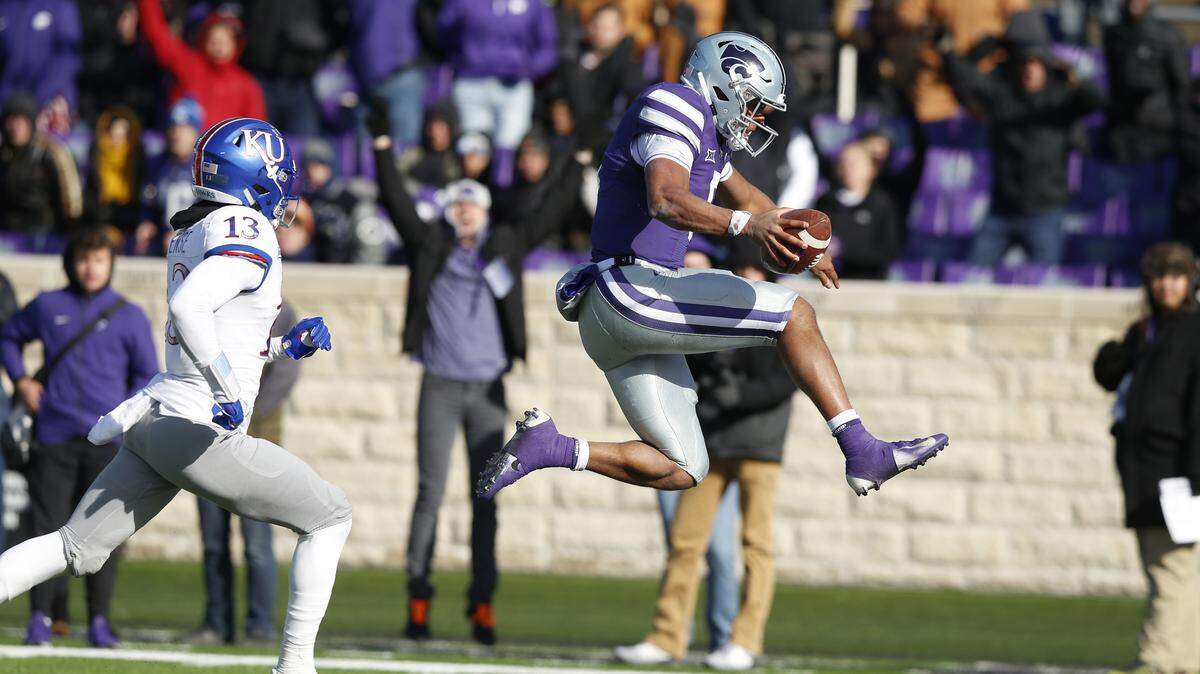 K-State quarterback Alex Delton leaps into the end zone as he scores the go-ahead touchdown Saturday against Kansas.