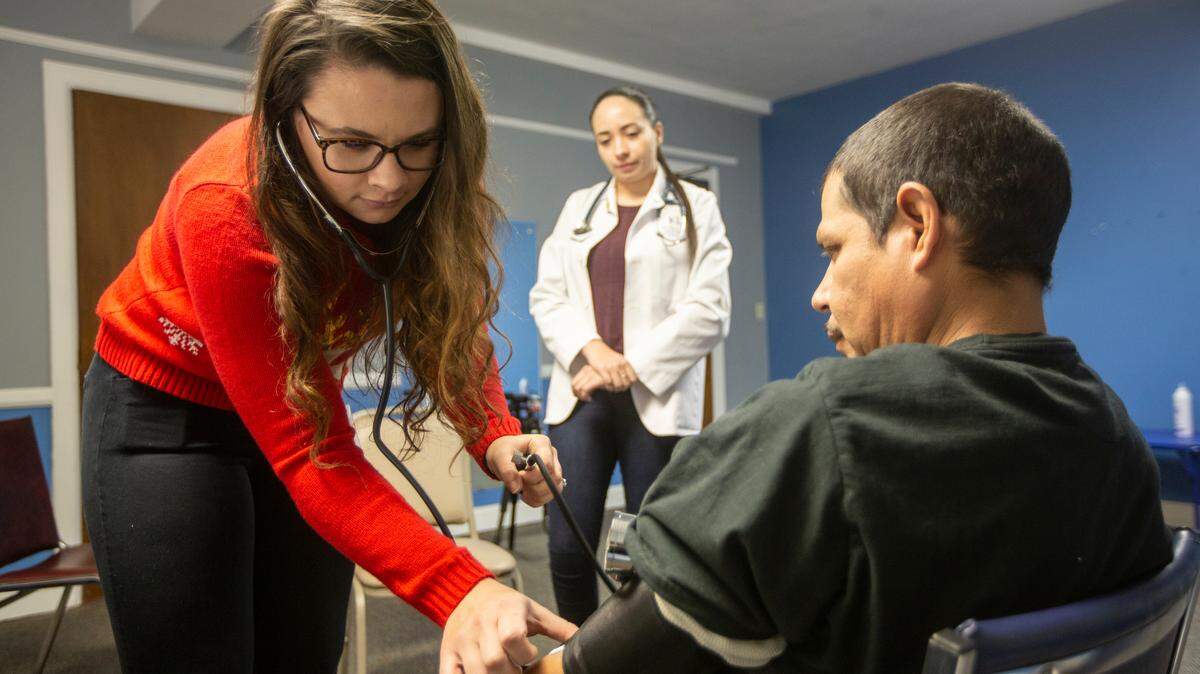 Stephanie Parks, a recent pre-med graduate from Wichita State, checks the blood pressure of Miguel Acuna while working at a health clinic at the former Central Christian Church building at Central and Market. JayDoc Community Clinic, the KU-sponsored health clinic that treats patients at the church on Thursday nights, is run in collaboration with the Guadalupe Clinic, an outreach effort by the Catholic Diocese of Wichita that provides healthcare to the uninsured and to those that canÕt otherwise afford it.