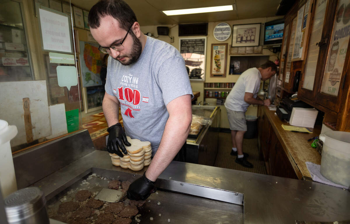Dane Vanatta grills up sliders at Salina’s The Cozy Inn, which is celebrating 100 years in business.