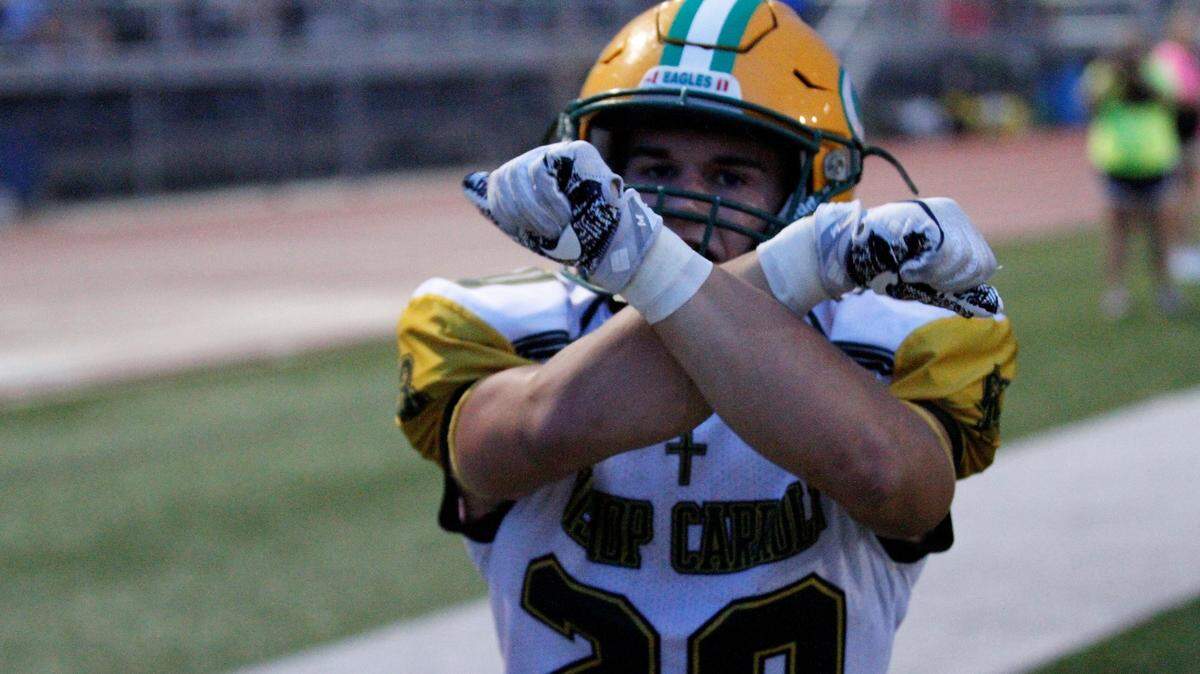Bishop Carroll’s Jackson Nichols throws up the X after scoring his second of three touchdowns in the Golden Eagles’ 36-20 win over Wichita Heights on Friday. (Sept. 7, 2018)