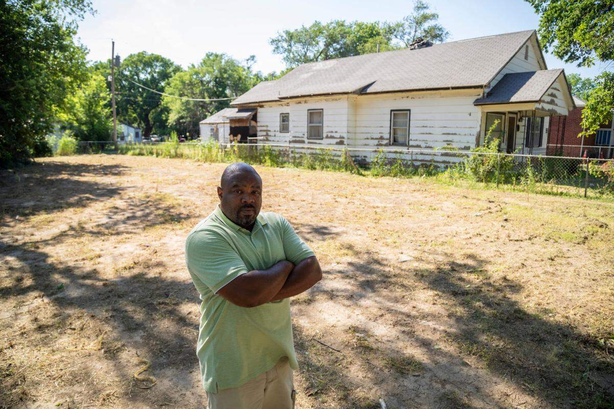 Jason Washington stands in the empty lot of 1523 N. Green. The home was demolished in July 2023. He’s working to save his grandmother’s house in the background from the same fate.