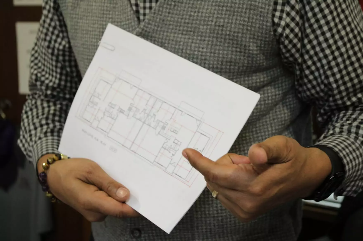 The Rev. Kevass Harding points to planning documents for one of the homes he will be working on.