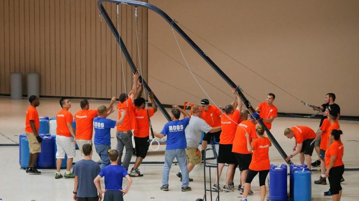 Volunteers set up gymnastics equipment at Century II for a YMCA National Gymnastics Championships.