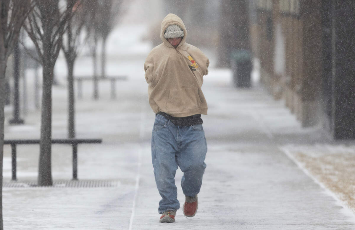 A pedestrian makes their way through Delano as freezing temperatures and snow descend on Wichita.
