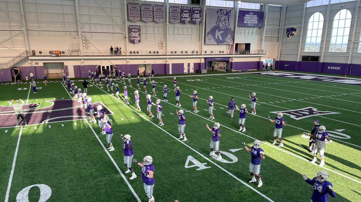 Kansas State football players warm up before a spring practice in Manhattan.