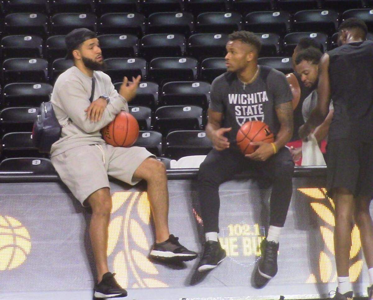 Shocker legend Fred VanVleet and current WSU player Dexter Dennis talk at Koch Arena on Wednesday night.