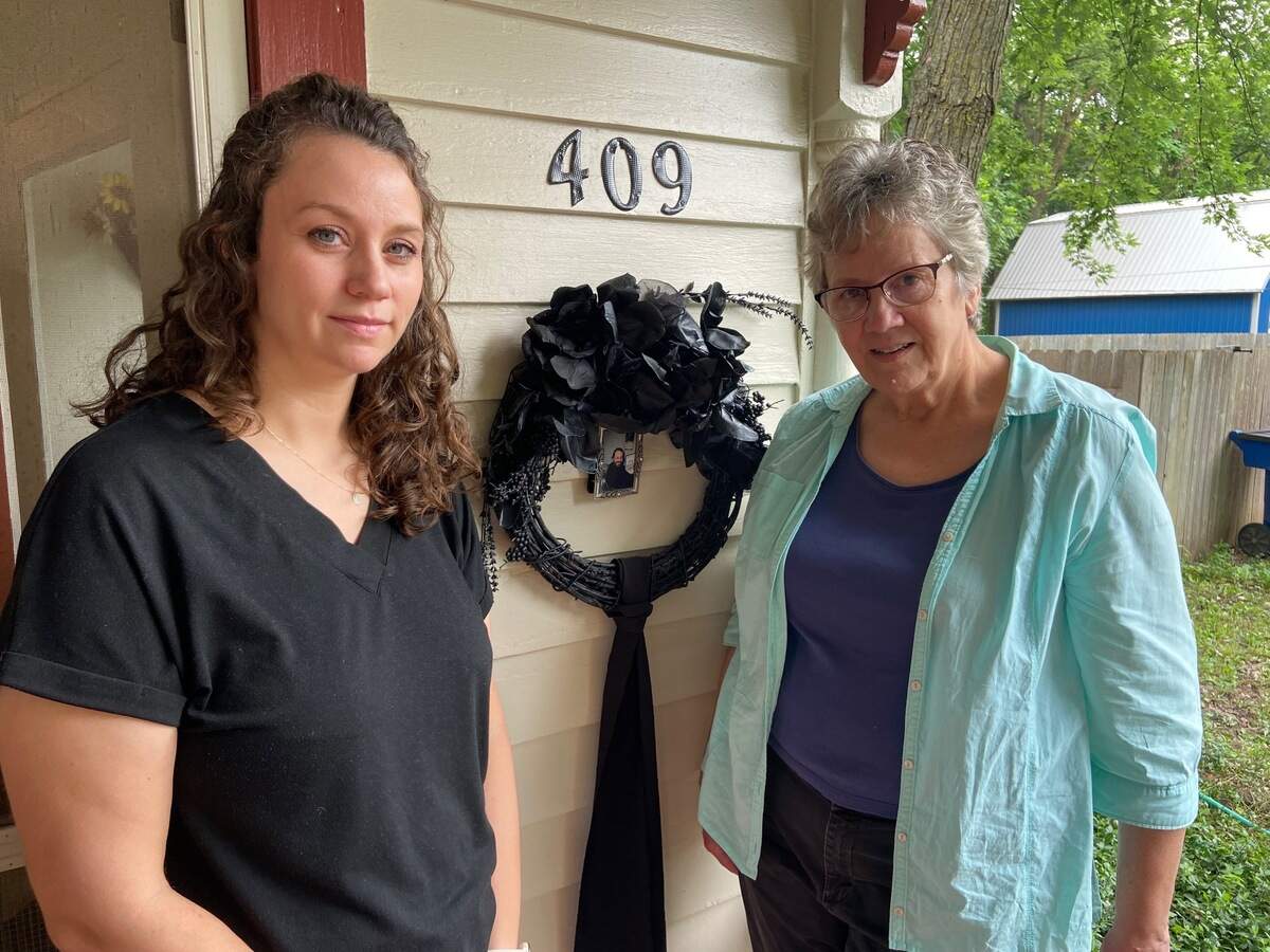 Rachel Andreas and her mother, Rhonda Horsch, show the black wreath the family put up after Anthony Horsch died.
