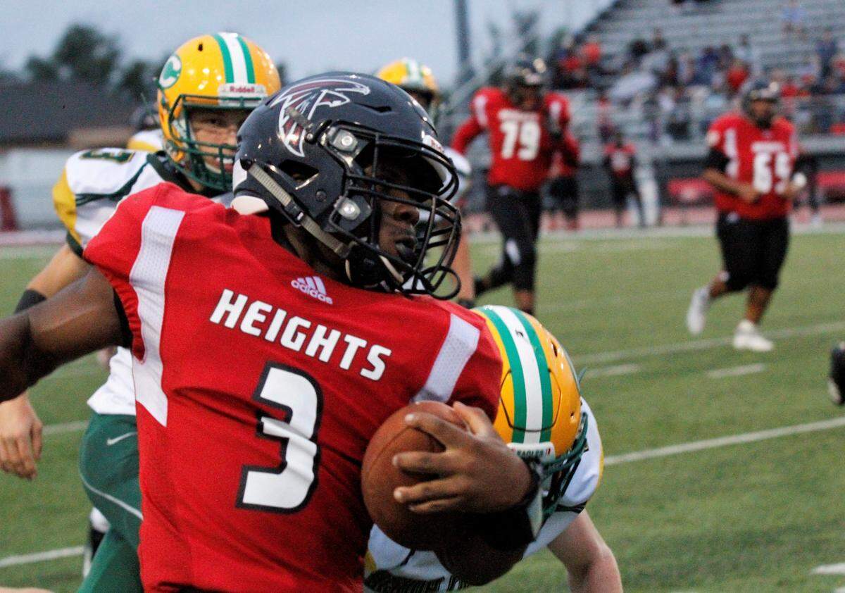 K’Vonte Baker, a Wichita Heights senior quarterback, eludes Bishop Carroll defenders in the Golden Eagles’ 36-20 September win.