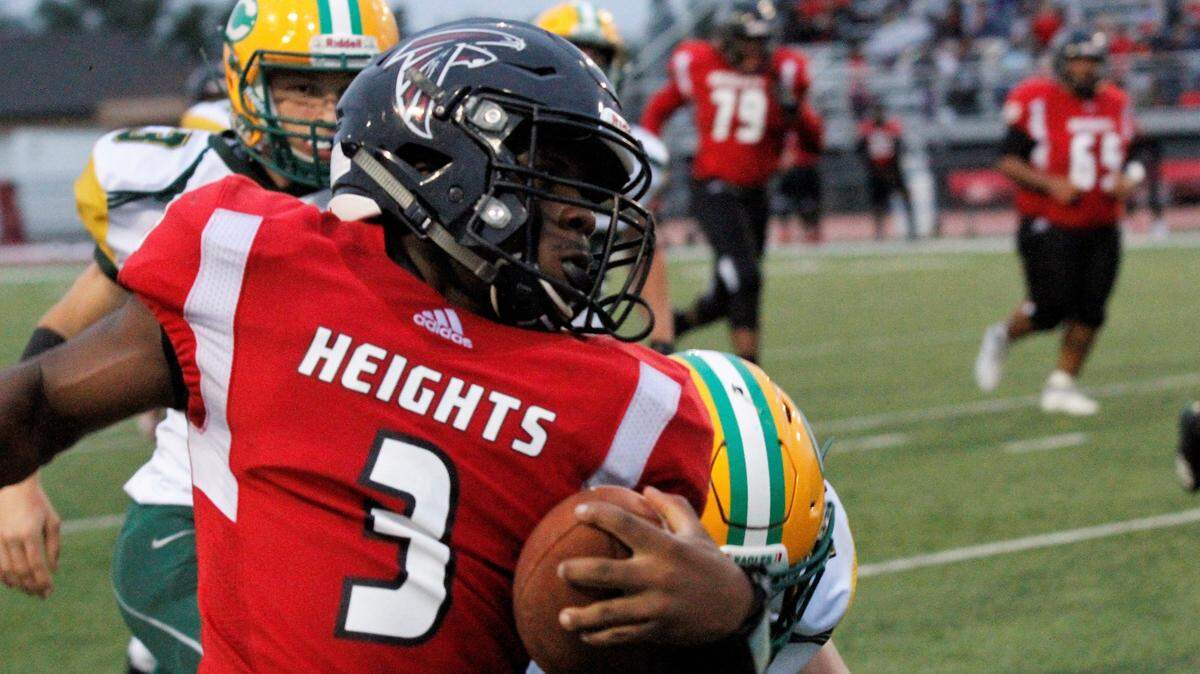 K’Vonte Baker, a Wichita Heights senior quarterback, eludes Bishop Carroll defenders in the Golden Eagles’ 36-20 September win.