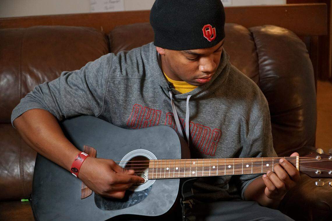 Wichita Northwest senior Marcus Hicks plays guitar in his living room. Hicks has verbally committed to Oklahoma. He enjoys music and art. (November 21, 2018)