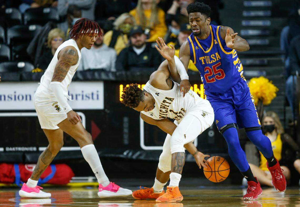 Wichita State’s Tyson Etienne gets tied up with Tulsa’s Rey Idowu during the first half of their game on Tuesday night at Koch Arena.