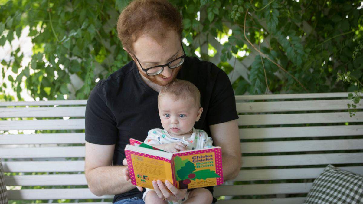 Wichita Eagle reporter Matt Riedl reads to his son Henry on their front porch recently.