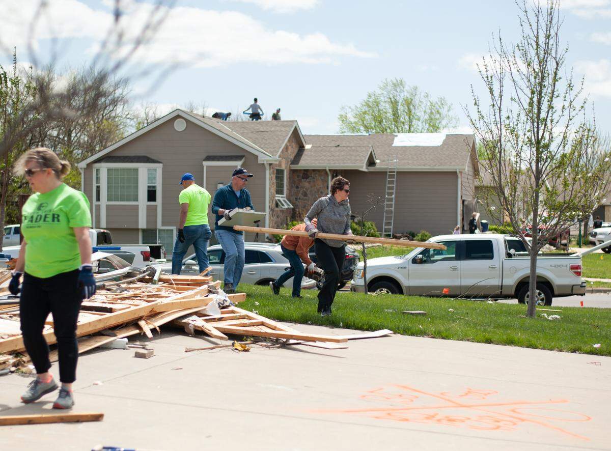 Andover neighborhood residents clean up debris created by the tornado that swept through the town and surrounding areas on Friday, April 30, 2022. (April 30, 2022)