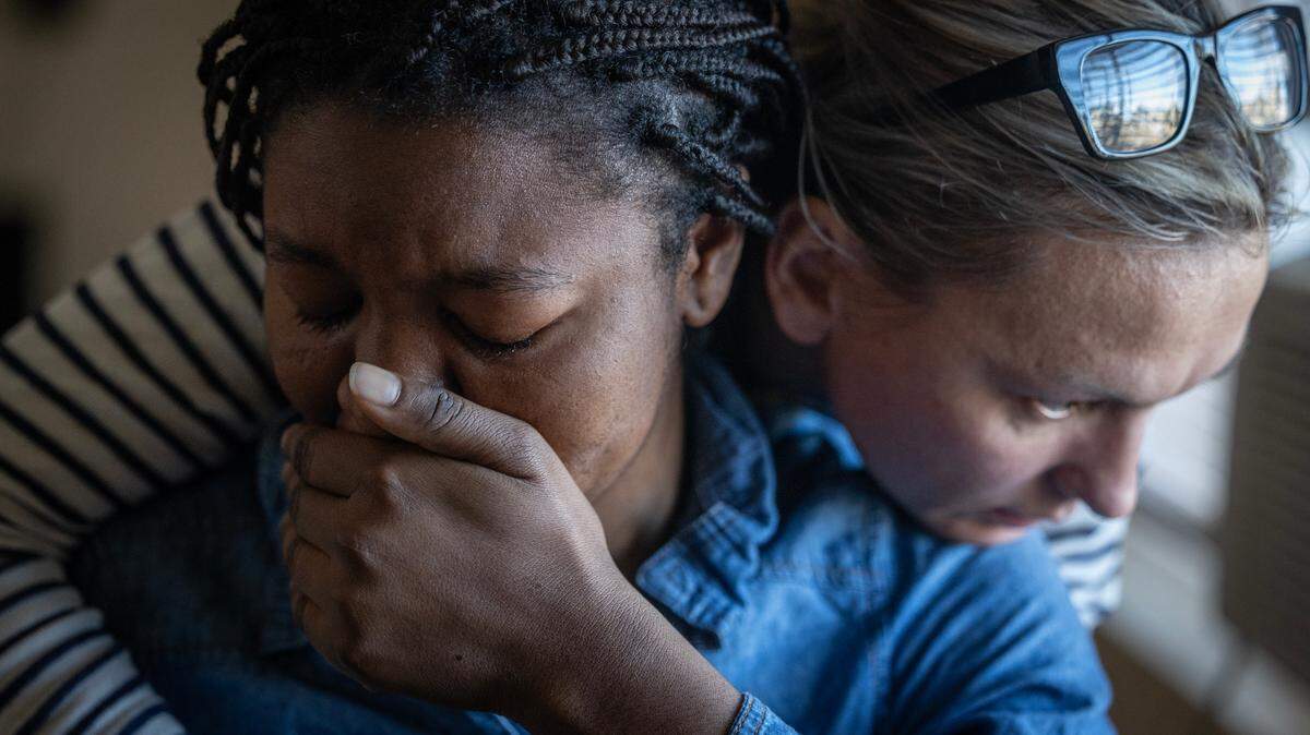 Tumba Kabengele, left, cries while recalling her difficult life in a refugee camp, and is comforted by Galyna Golyshevska of International Rescue Committee Kansas.