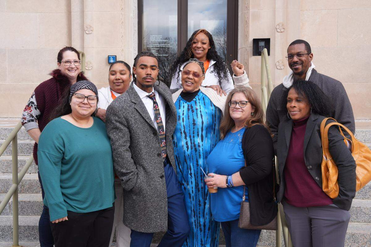 Marquan Teetz, the brother of Cedric Lofton who brought the suit, is surrounded by supporters on the federal courthouse steps after the verdict.