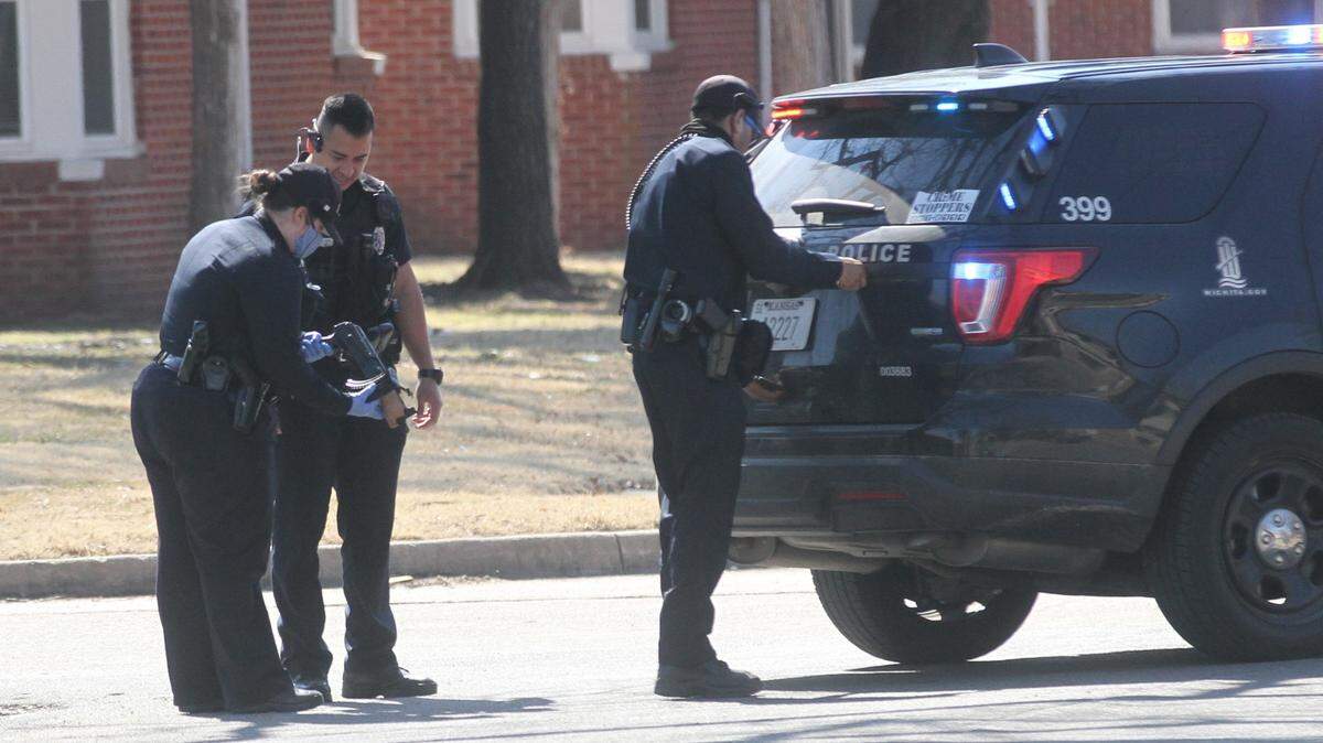 Wichita police look at what appears to be a gun and a gun magazine after shots were fired in the 1600 block of South Battin on Saturday.