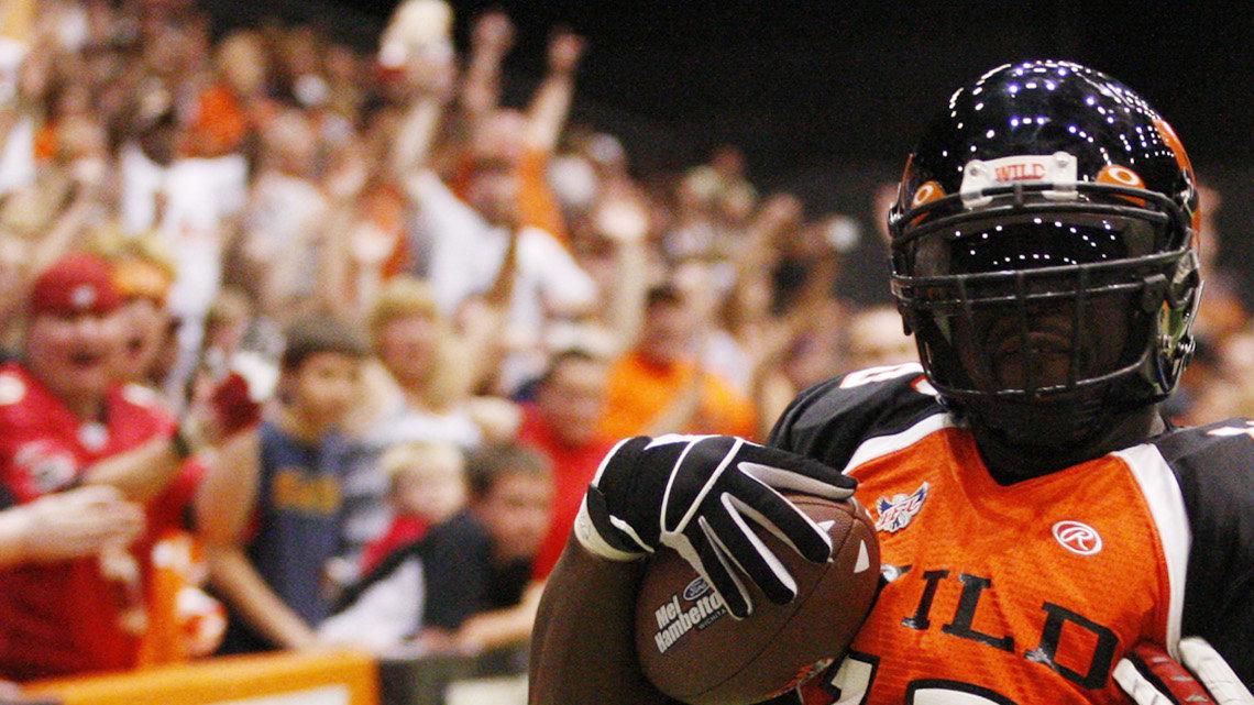 The Wild's QB Dixie Wooten scores a TD in the second quarter against Bloomington's Terrell Mayberry in the first round of the Indoor Football League playoffs at Hartman Arena on Saturday. (June 26, 2010)